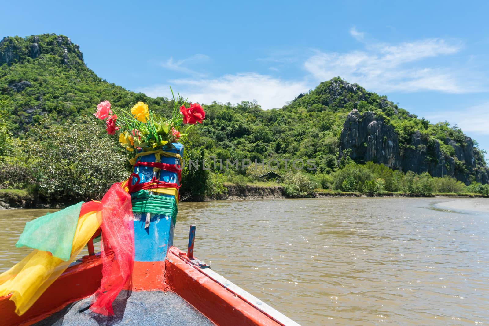 Khao Dang canal boat trip at Prachuap Khiri Khan Thailand. Boat or fishing boat and rock or stone mountain or hill with blue sky and cloud and green tree and water. Landscape or scenery summer concept for boat trip