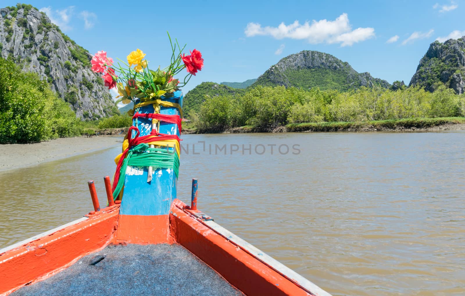 Khao Dang canal boat trip at Prachuap Khiri Khan Thailand. Boat or fishing boat and rock or stone mountain or hill with blue sky and cloud and 
green tree and water. Landscape or scenery summer concept for boat trip