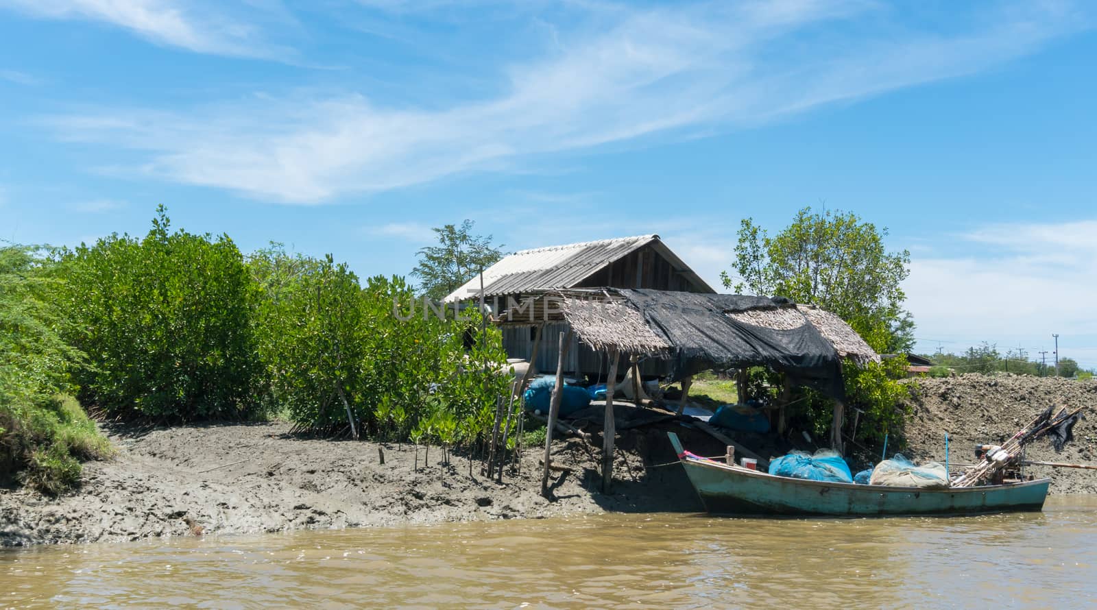 Fishing village and fishing boat at Khao Dang village. Old home and fishing boat and blue sky and cloud and water and green tree. Landscape or scenery summer concept for boat trip