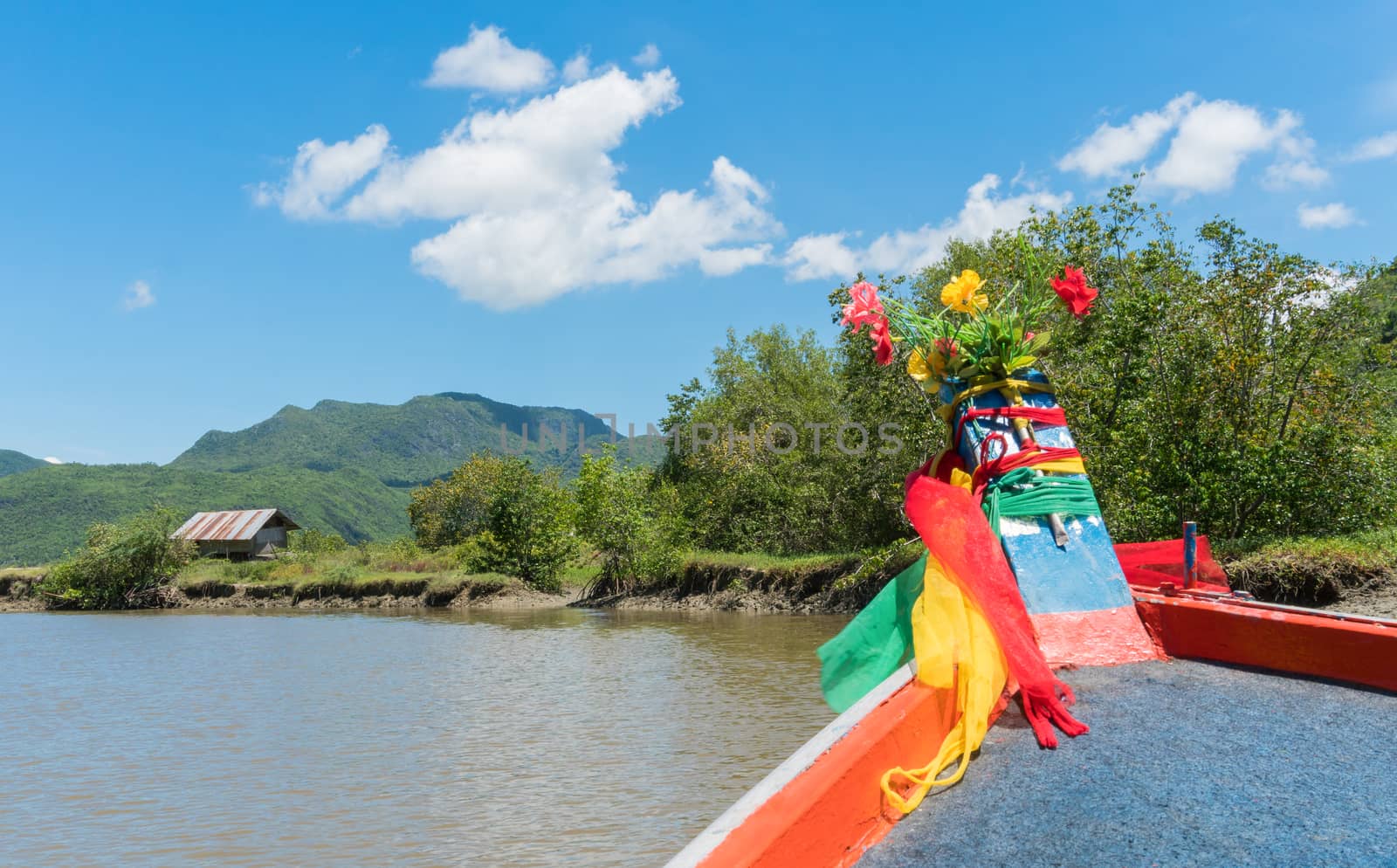 Khao Daeng canal boat trip at Prachuap Khiri Khan Thailand. Boat or fishing boat and rock or stone mountain or hill with blue sky and cloud and green tree and water. Landscape or scenery summer concept for boat trip