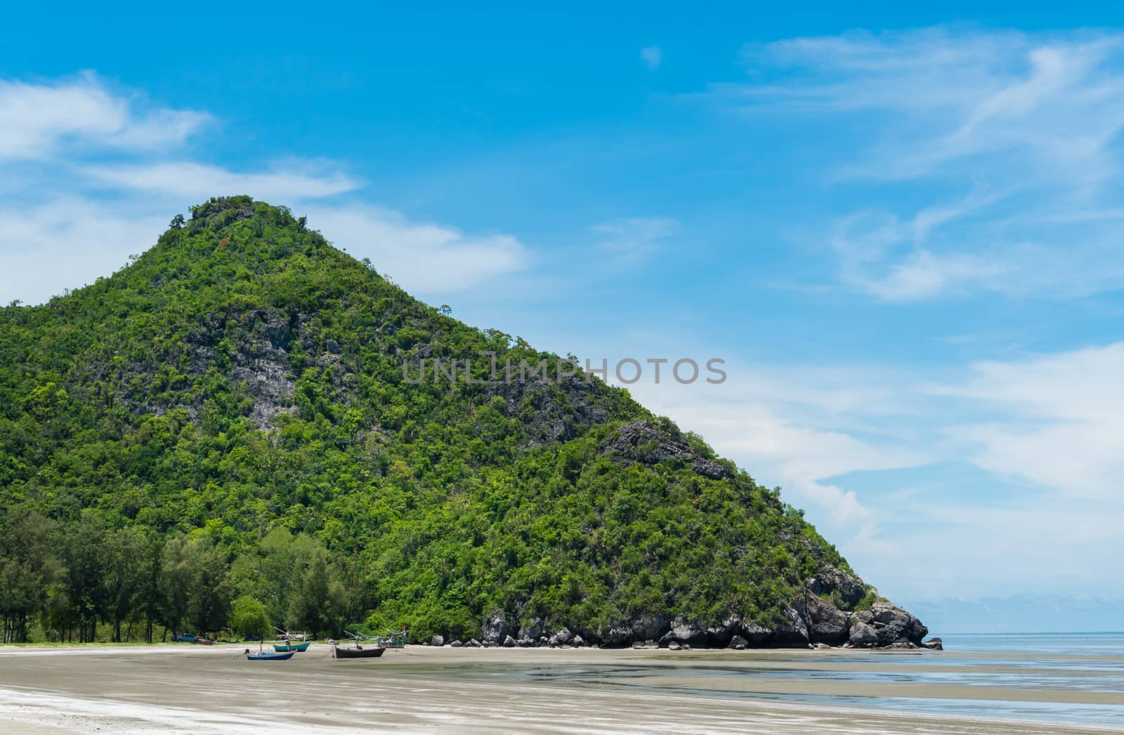 Rock or stone mountain or hill and blue sky and fishing boat close up at Sam Phraya beach Prachuap Khiri Khan Thailand. Landscape or scenery in 
natural for summer concept