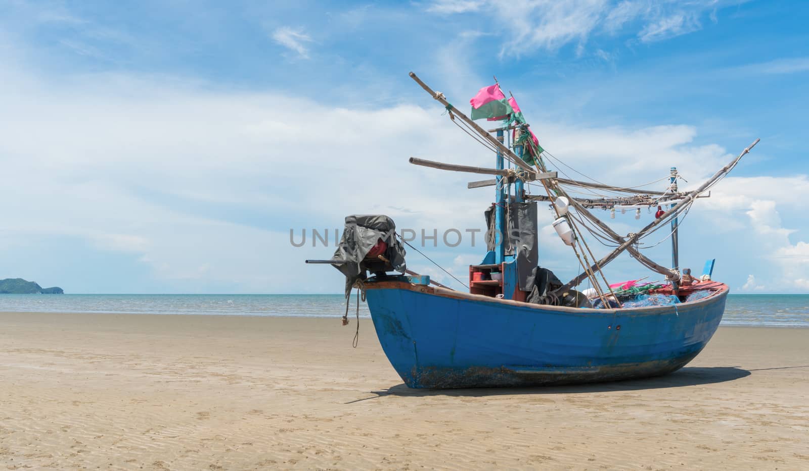 Blue fishing boat or fisherman boat or ship on Sam Roi Yod bech Prachuap Khiri Khan Thailand with blue sky and cloud and blue sea. Landscape or scenery for summer season concept