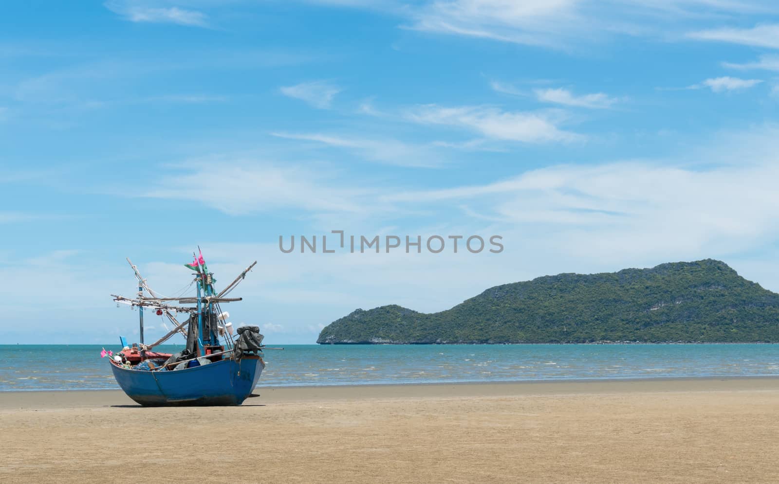 Blue fishing boat or fisherman boat or ship on Sam Roi Yod bech Prachuap Khiri Khan Thailand with blue sky and cloud and blue sea and 
mountain or hill. Landscape or scenery for summer season concept