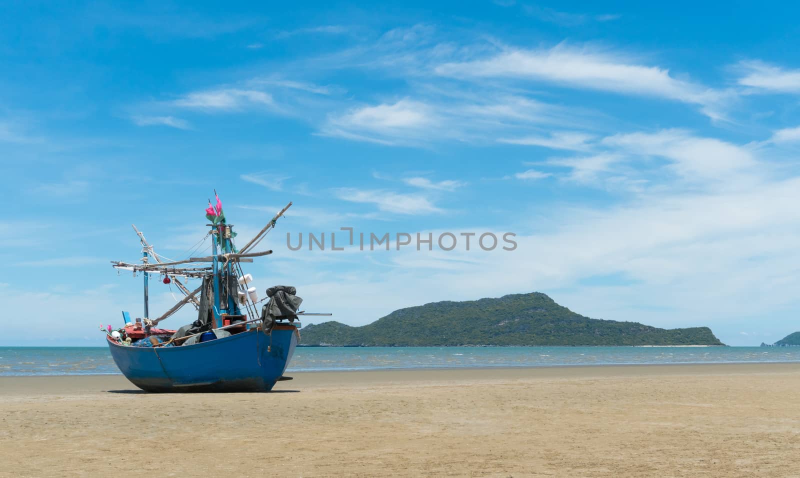 Blue fishing boat or fisherman boat or ship on Sam Roi Yod bech Prachuap Khiri Khan Thailand with blue sky and cloud and blue sea and 
mountain or hill. Landscape or scenery for summer season concept