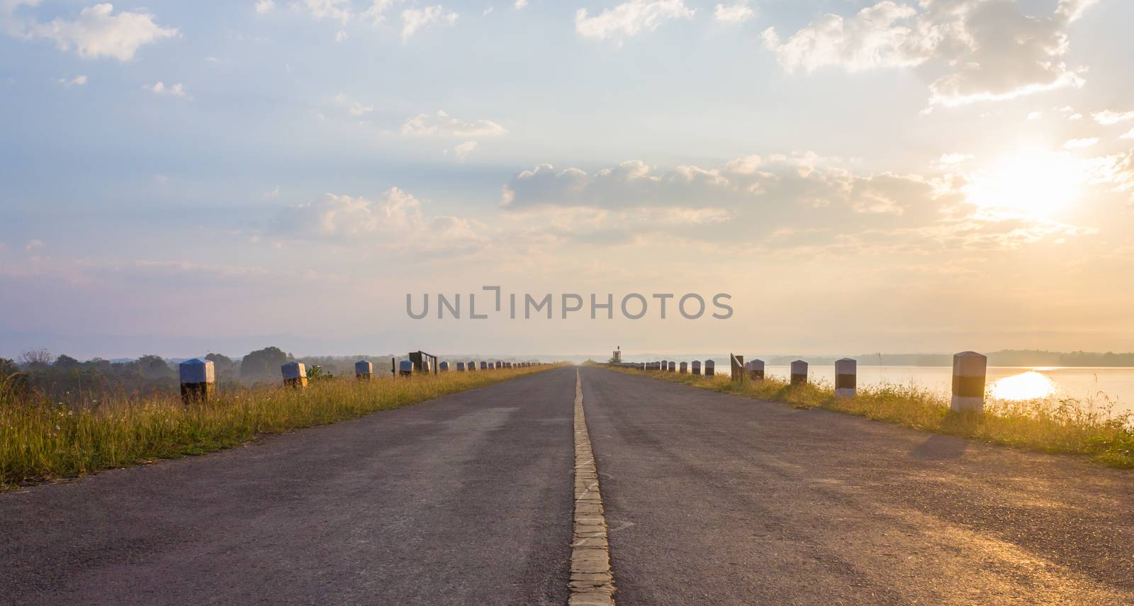 The Road on Dam or Sluice with Sunshine Blue Sky Water and Cloud Center Frame. Road on dam or sluice and natural landscape cloud blue sky sunshine fog and water