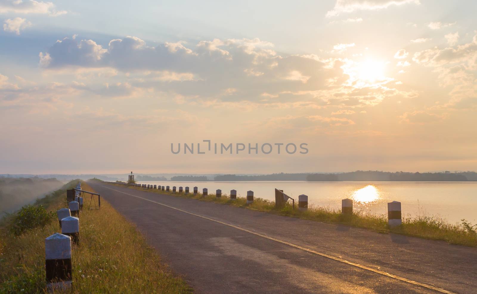 The Road on Dam or Sluice with Sunshine Blue Sky Water and Cloud. Road on dam or sluice and natural landscape cloud blue sky sunshine fog and water