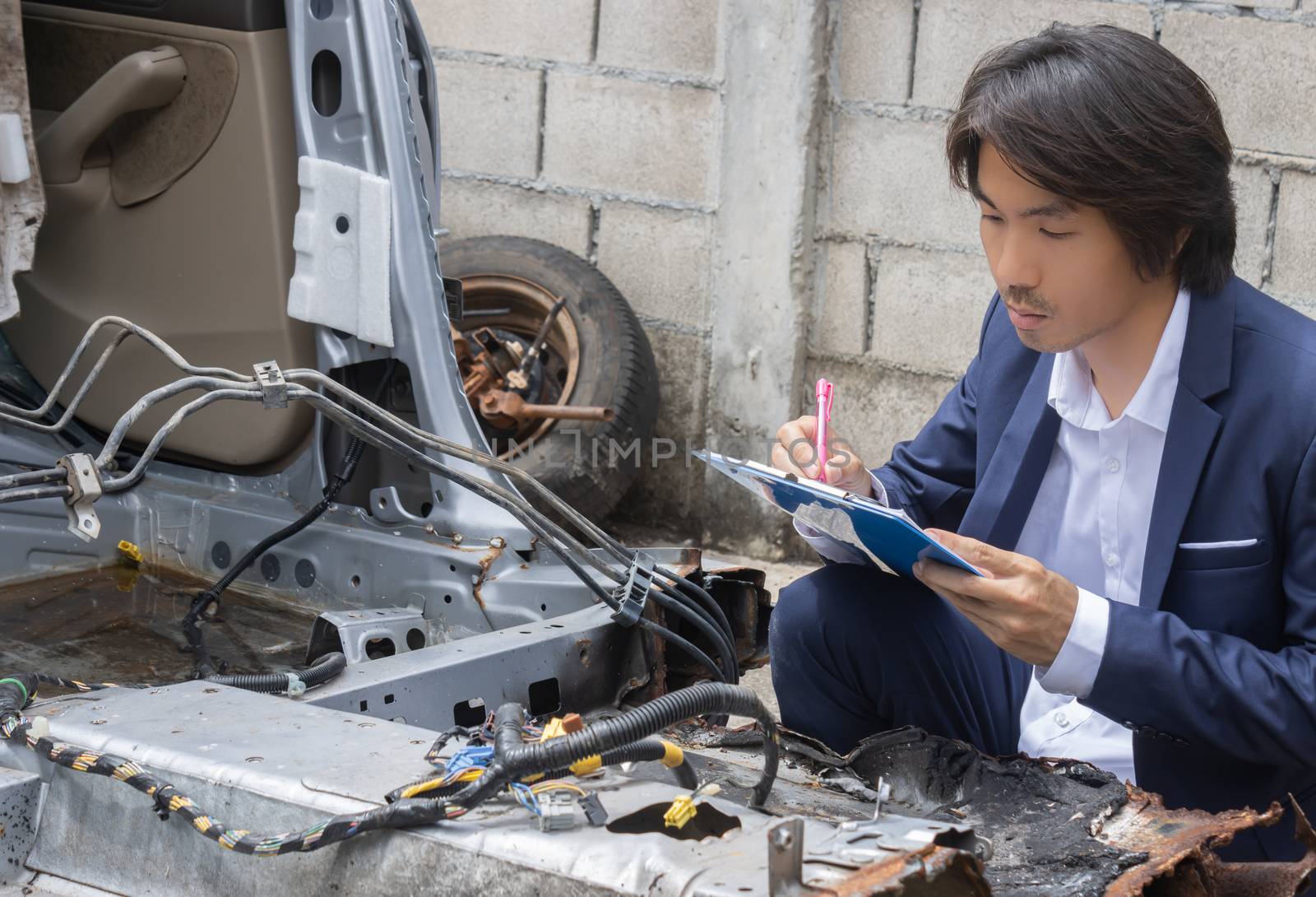 Asian Insurance Agent or Insurance Agency in Suit Inspecting Car Crash from Accident and Write Report for Insurance Claim at Outdoor Place in Serious Emotion