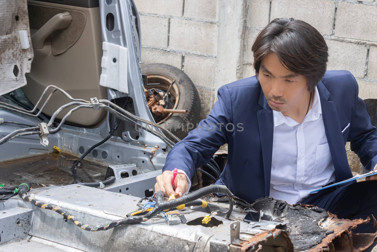 Asian Insurance Agent or Insurance Agency in Suit Inspecting Car Crash from Accident for Insurance Claim at Outdoor Place