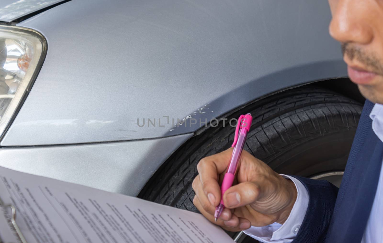 Asian Insurance Agent or Insurance Agency in Suit Checking Car Crash Data Report from Accident for Claim at Outdoor Place