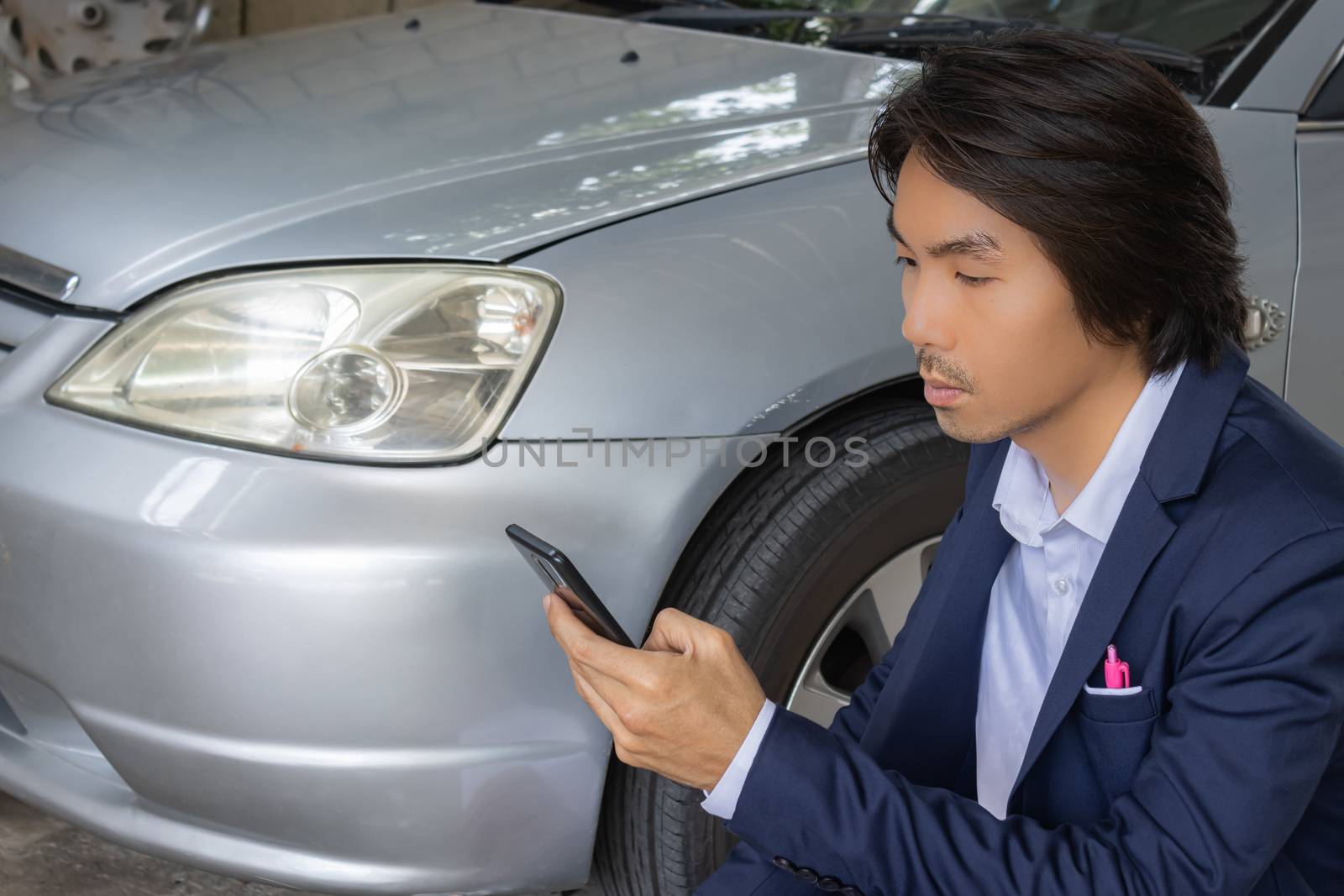Asian Insurance Agent or Insurance Agency in Suit Touch Smartphone and Inspecting Car Crash from Accident for Claim at Outdoor Place