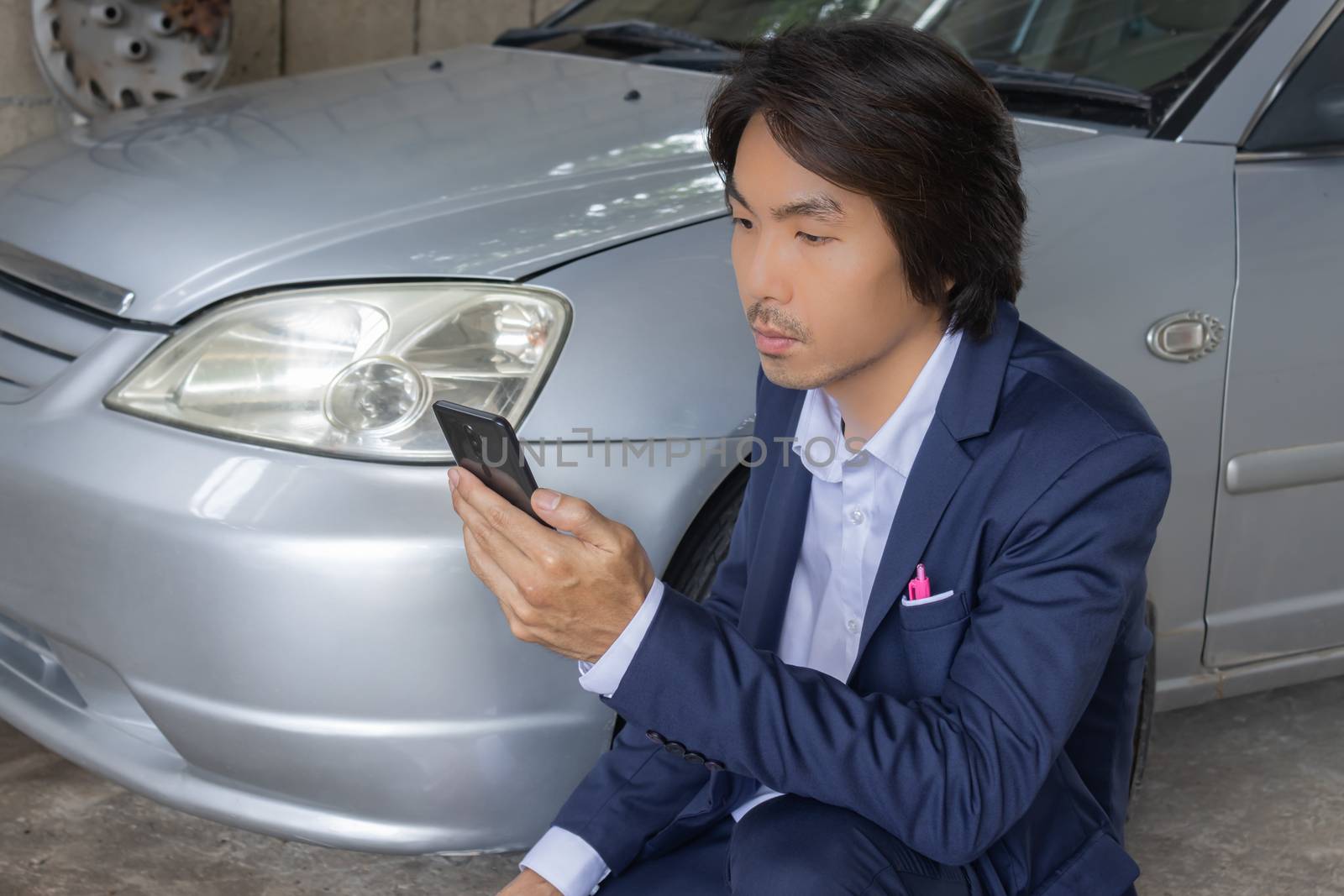 Asian Insurance Agent or Insurance Agency in Suit See Smartphone and Inspecting Car Crash from Accident for Claim at Outdoor Place