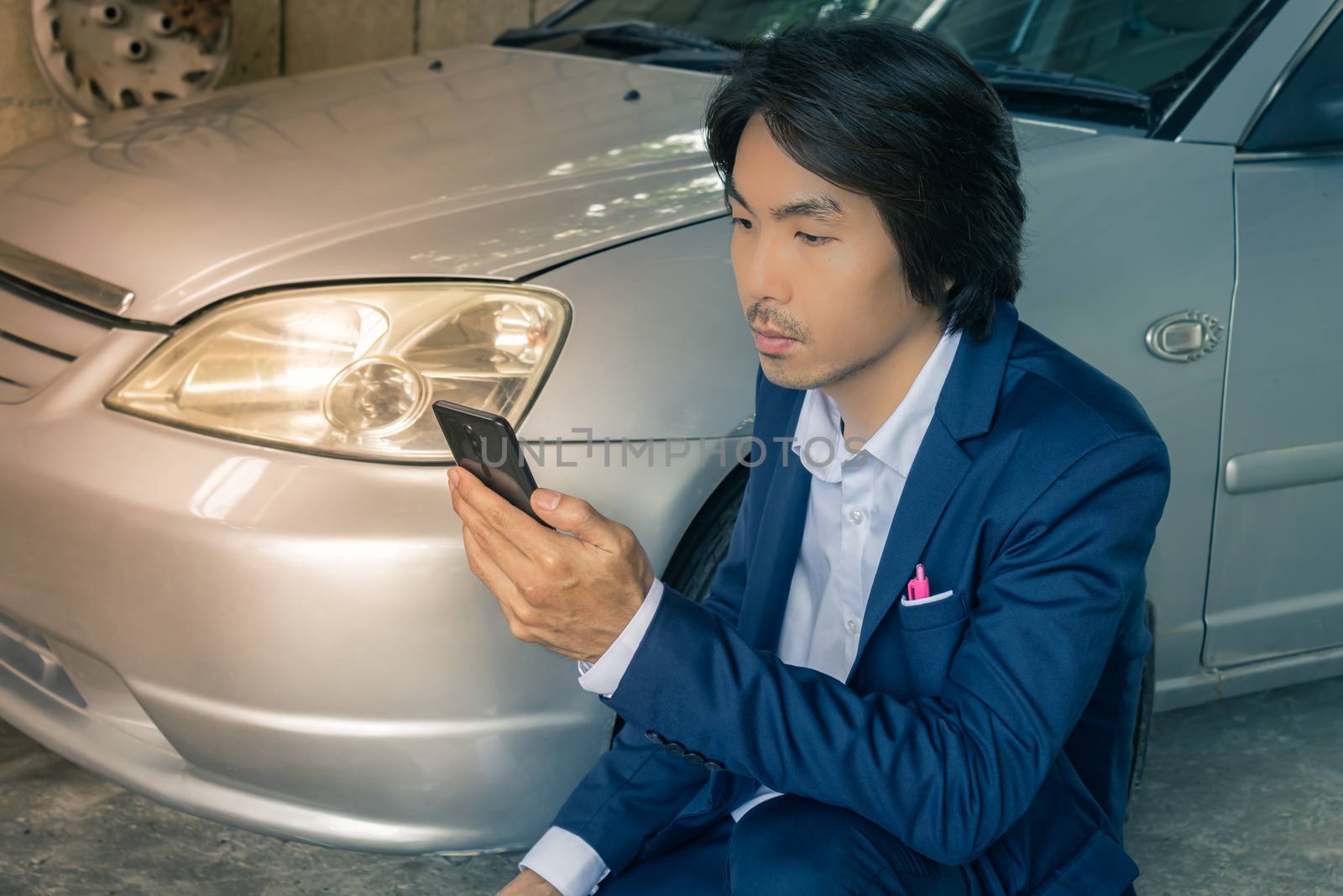 Asian Insurance Agent or Insurance Agency in Suit See Smartphone and Inspecting Car Crash from Accident for Claim at Outdoor Place in Vintage Tone