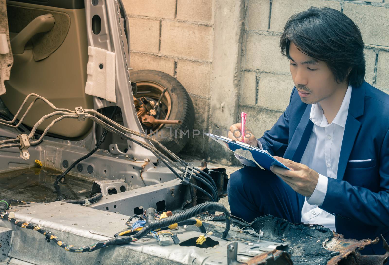 Asian Insurance Agent or Insurance Agency in Suit Inspecting Car Crash from Accident and Write Report at Side View for Insurance Claim at Outdoor Place in Serious Emotion in Vintage Tone