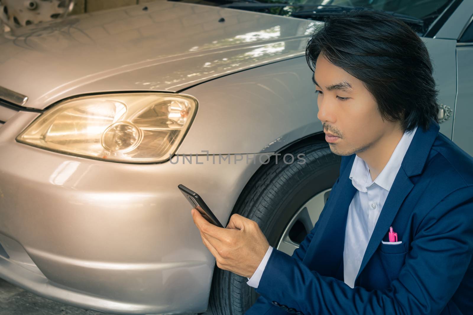Asian Insurance Agent or Insurance Agency in Suit Touch Smartphone and Inspecting Car Crash from Accident for Claim at Outdoor Place in Vintage Tone