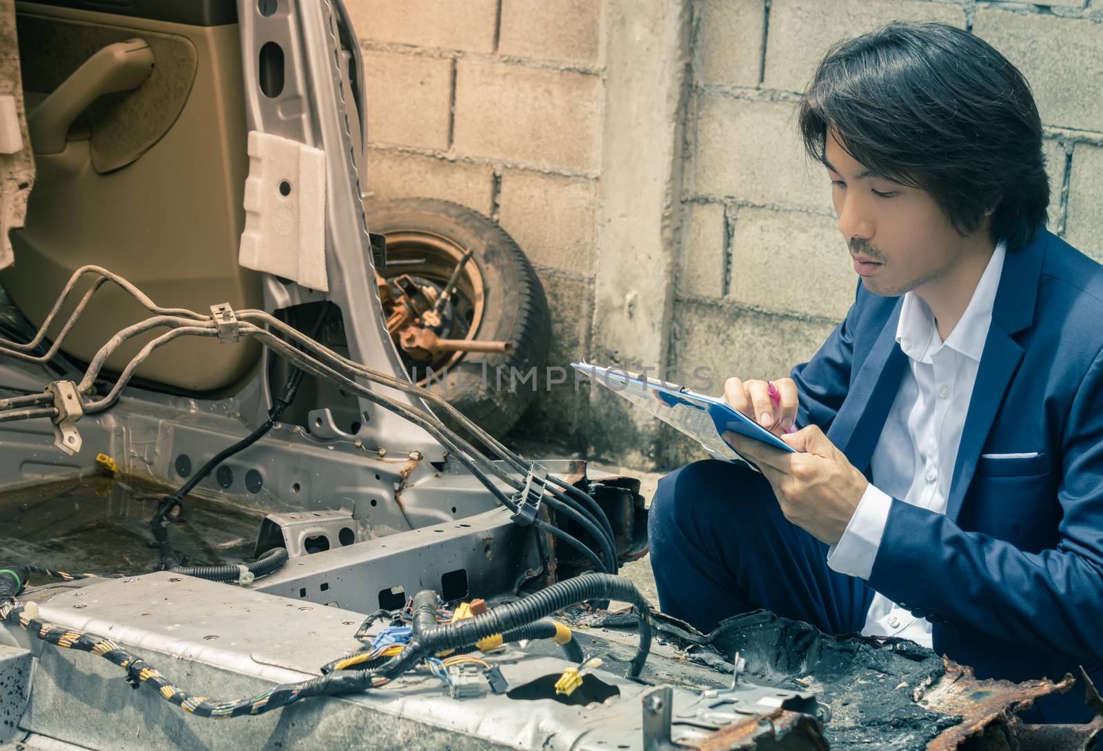 Asian Insurance Agent or Insurance Agency in Suit Inspecting Car Crash from Accident and Write Report at Side View for Insurance Claim at Outdoor Place in Vintage Tone