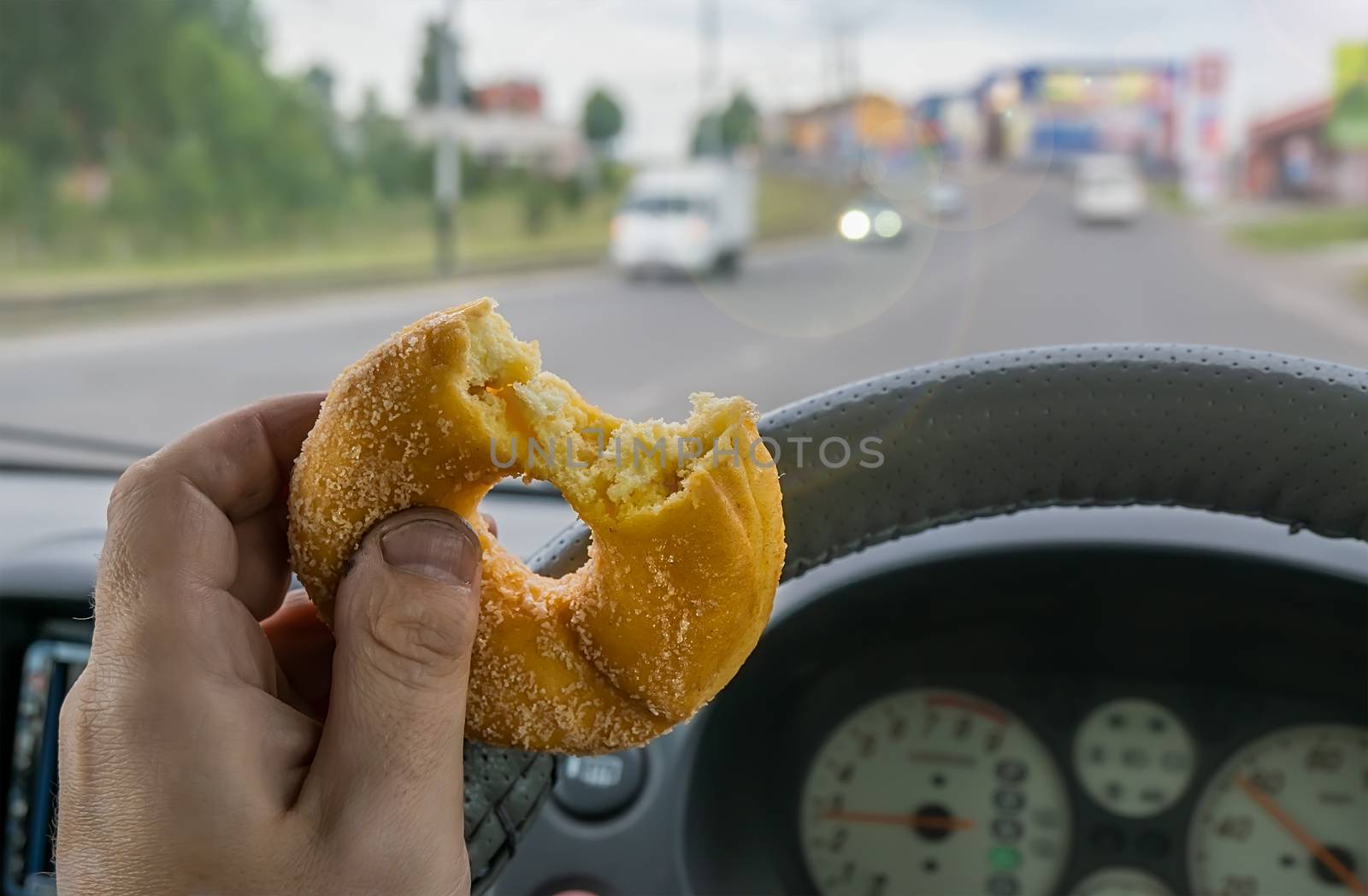 food, cookies, sweet bagel in the hand of a car driver while driving around the city