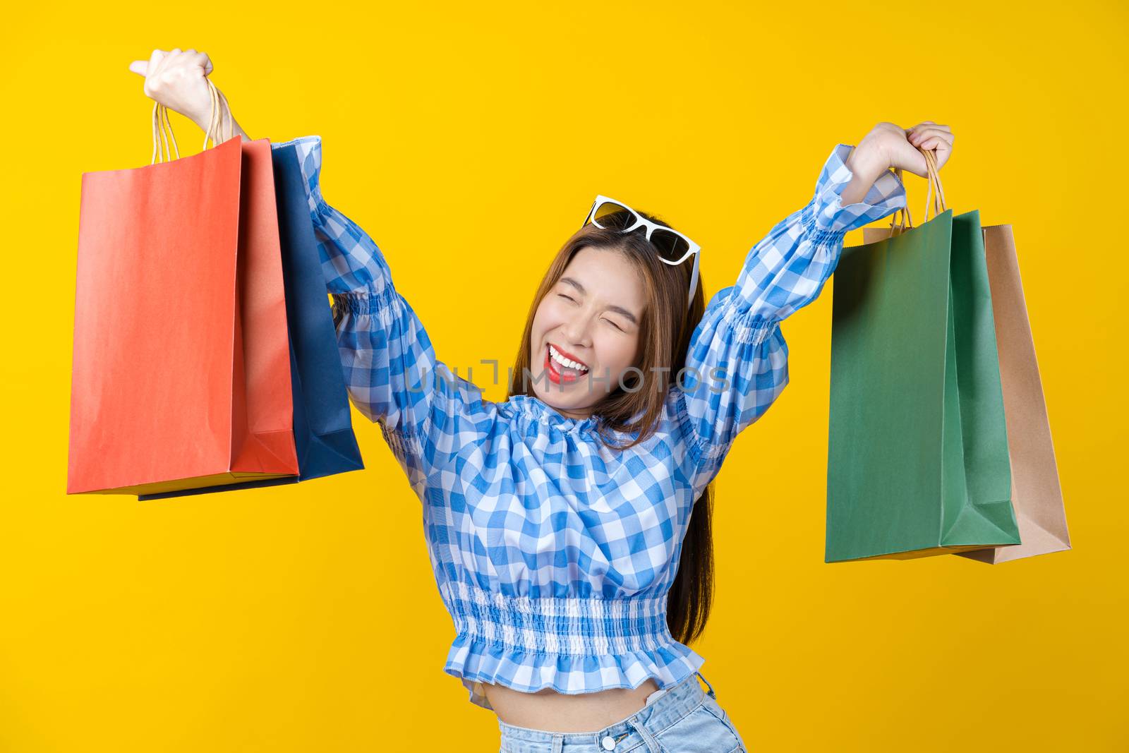 Attractive Asian smiling young woman Carrying shopping coloful b by Tzido