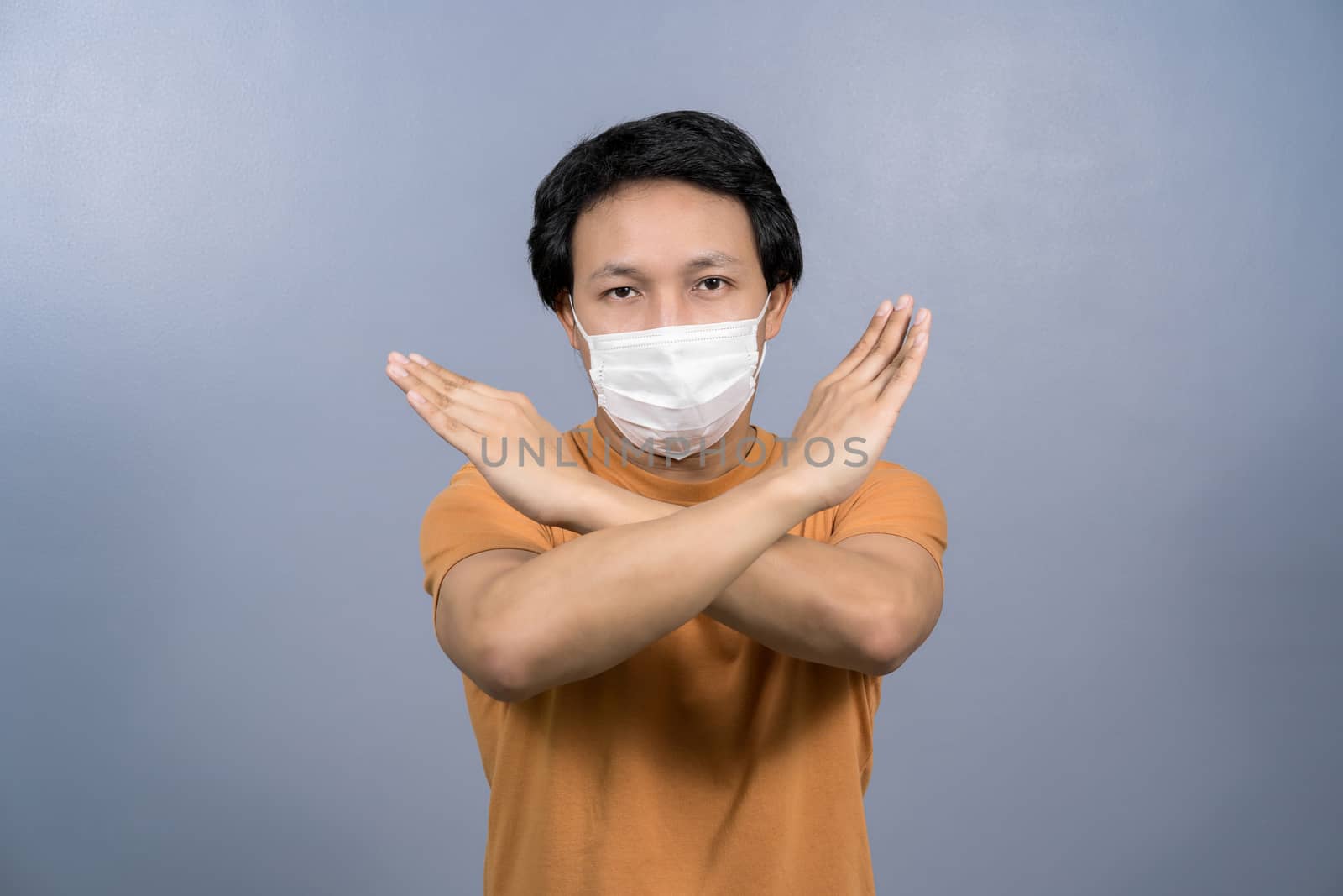 Portrait of asian male wearing face surgical mask and say no act by Tzido