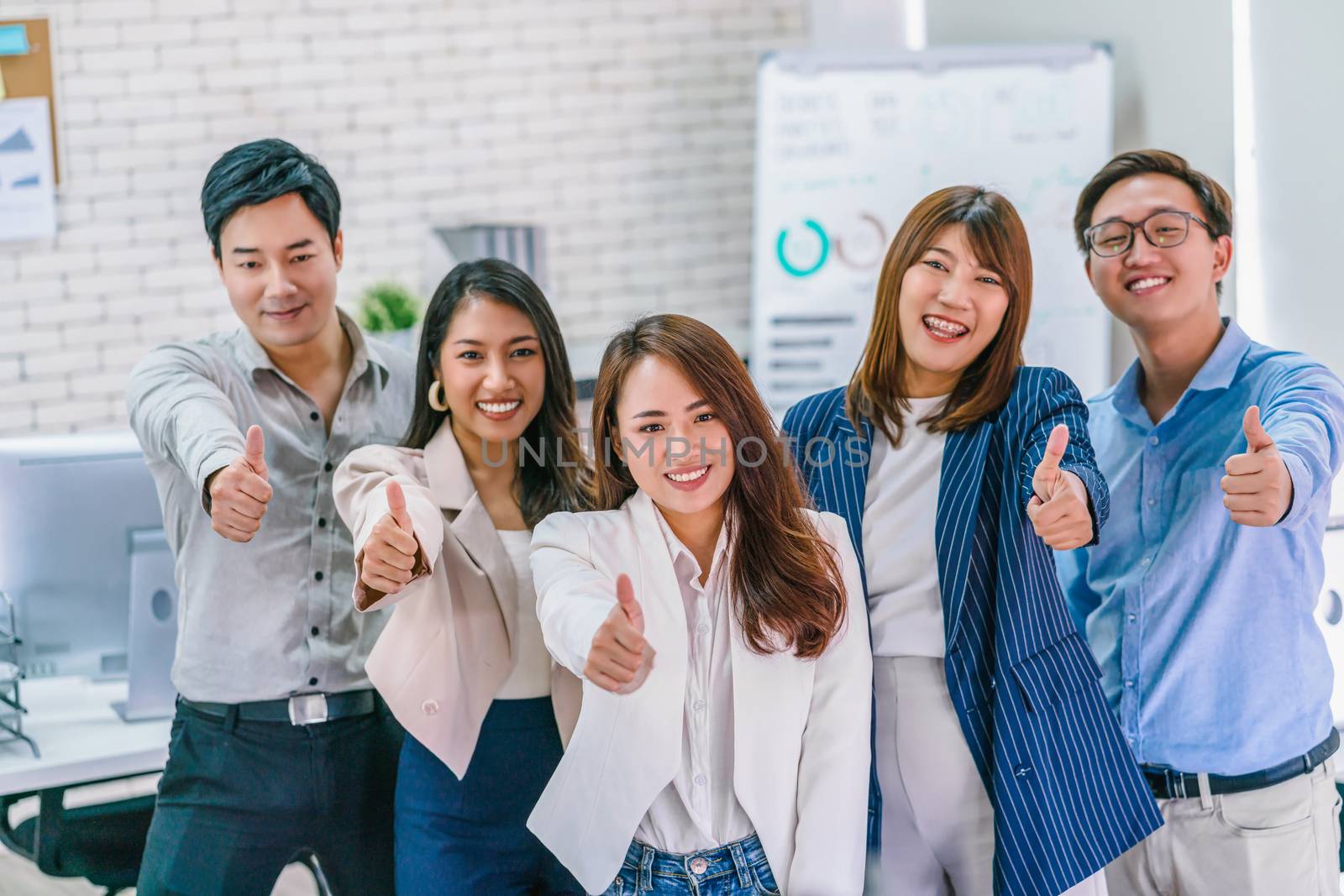 Group of Asian Business people showing thumbs up and looking at by Tzido