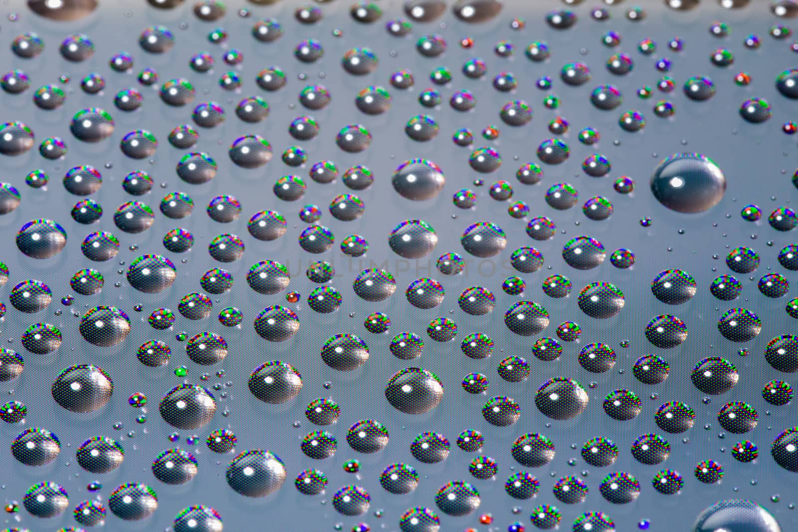 many small water drops on the surface of cellphone hydriphobic coated glass screen, close-up with selective focus and visible subpixel rgb triads