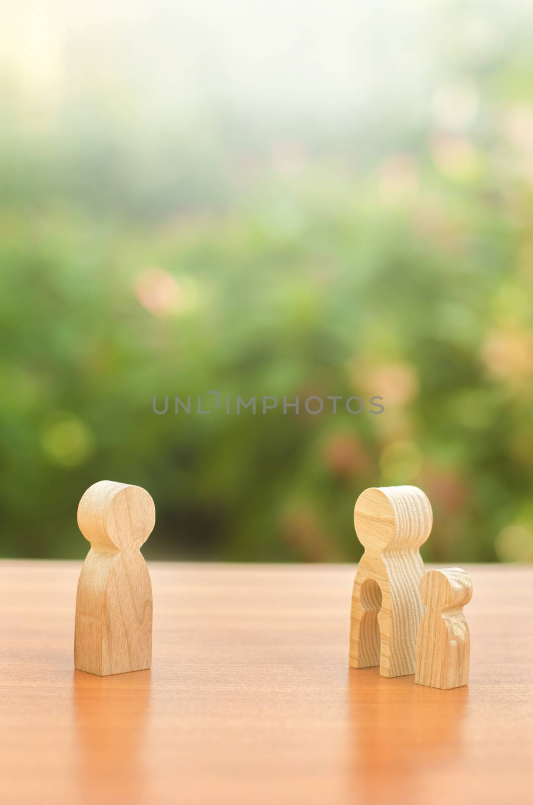 Wooden figures of a mother with a child stands apart from the father. Deprivation of parental rights. The child stay with the mother. Conflict resolution in court. Protection of mother s rights