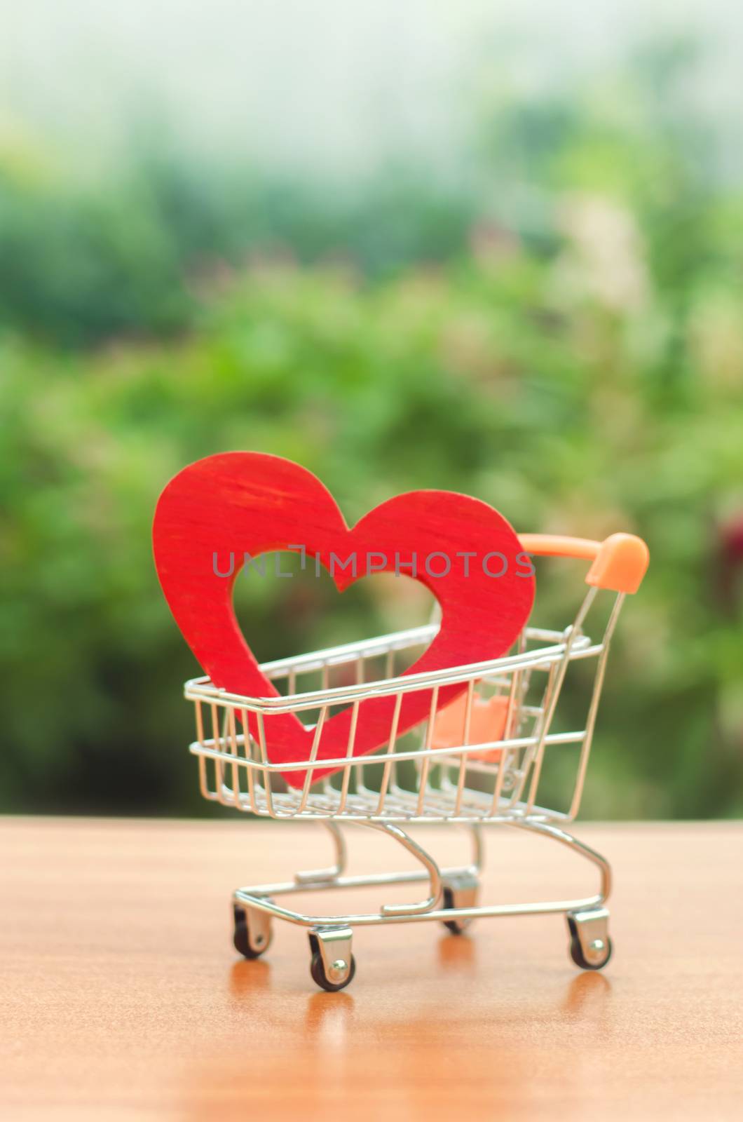 Red wooden heart in the trading cart. concept of buying love. nature background. Health care and purchase of medicines. Health care budget. Love for shopping. Favorite store. Buy love and happiness. by iLixe48