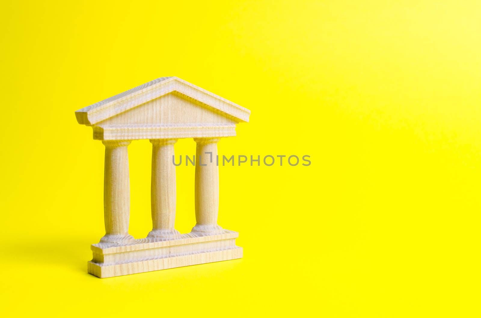 wooden government building on a yellow background. The authorities, the sovereignty of the country and the rule of law. concept of state administration and economic institutions. Bank or university