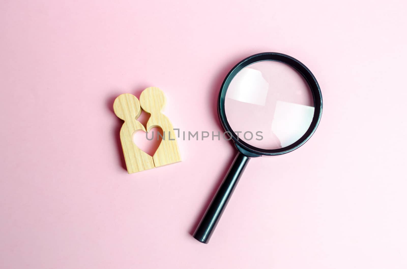 A young pair of lovers and a magnifying glass. The concept of finding a couple on Valentine's Day. Declaration of love and the creation of strong love relationships. Dating and flirt, search for love