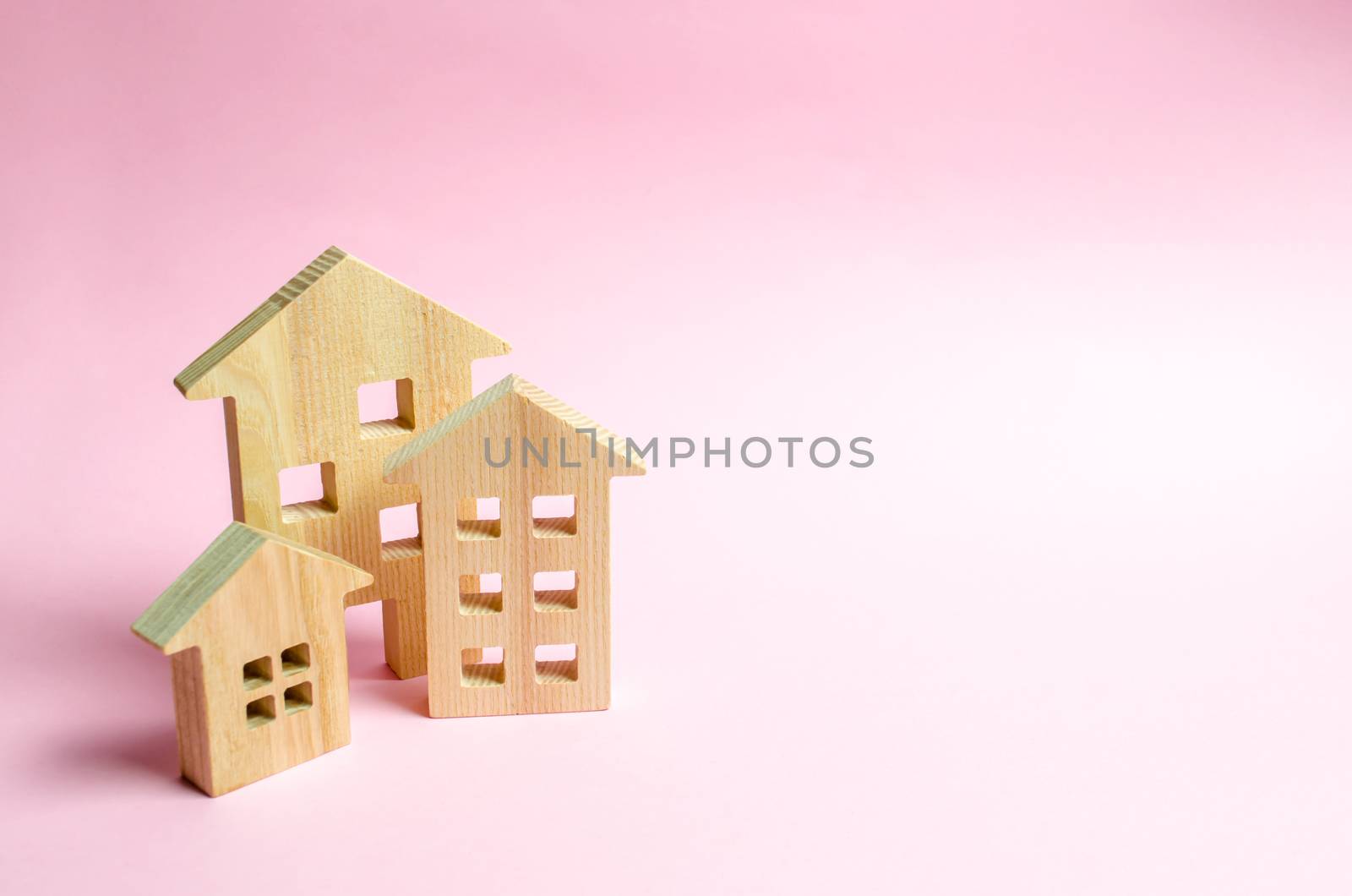 Wooden houses on a pink background. The concept of the city or town. Investing in real estate, buying a house. Management and business management, market coverage. Construction of buildings.