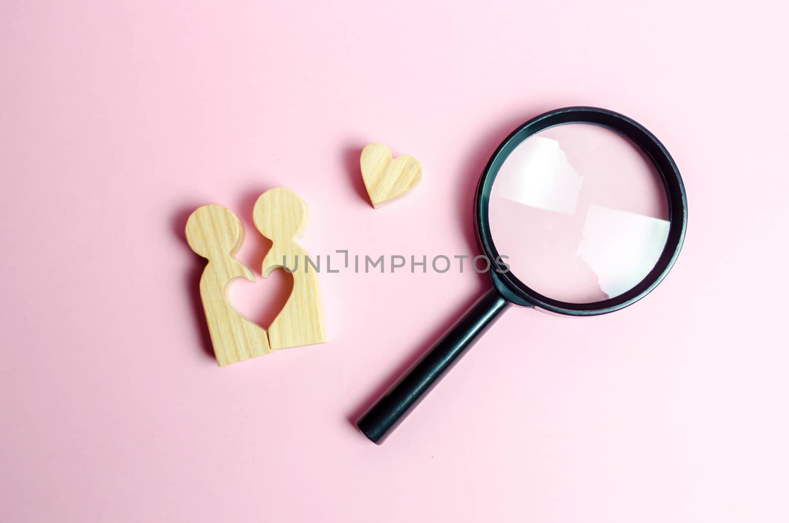 A young pair of lovers and a magnifying glass. Search for love and creation of strong love relationships. Dating and flirt, search for a love partner. concept of finding a couple on Valentine's Day.