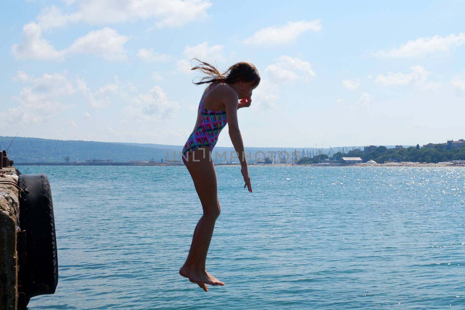 ggirl dives into the sea against the horizonirl dives into the sea against the horizon