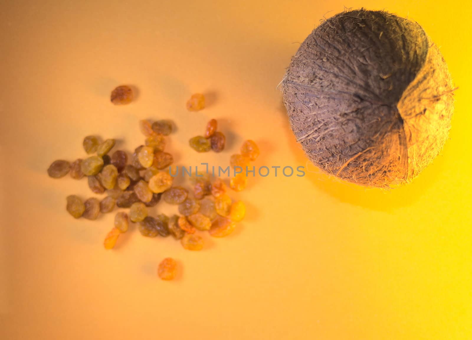 light bright composition: tropical coconut and raisins on a yellow background