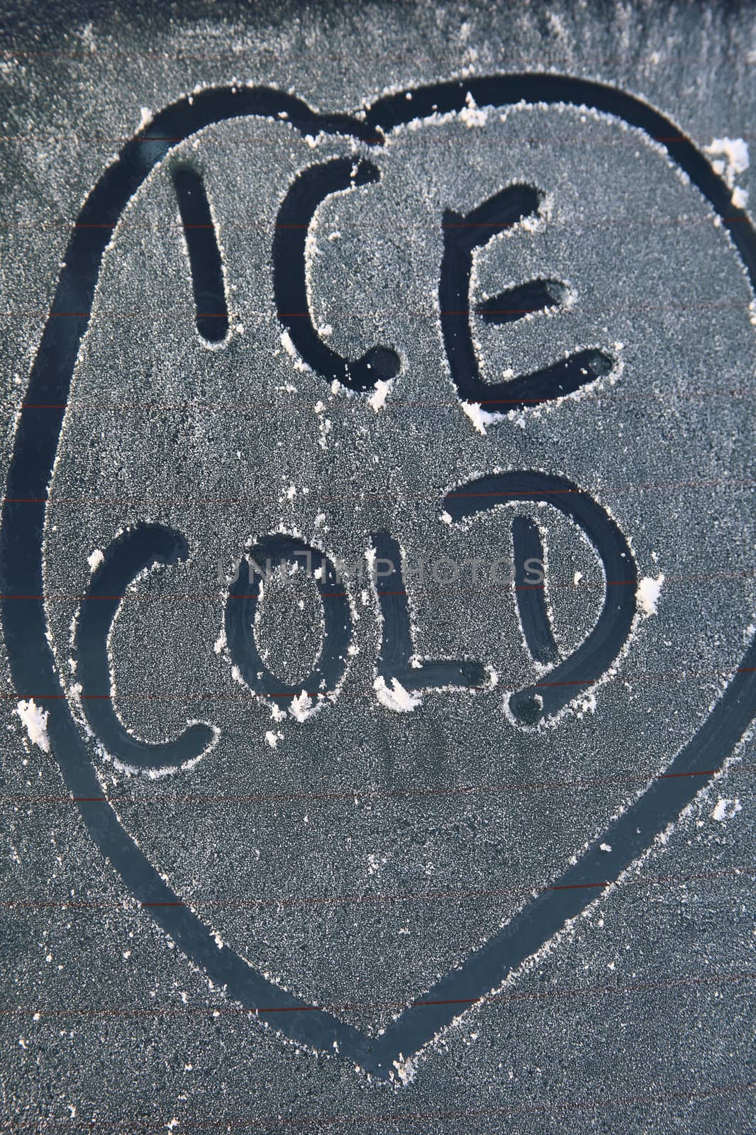 Frozen car window with a frost ice cold message text sign in the winter stock photo