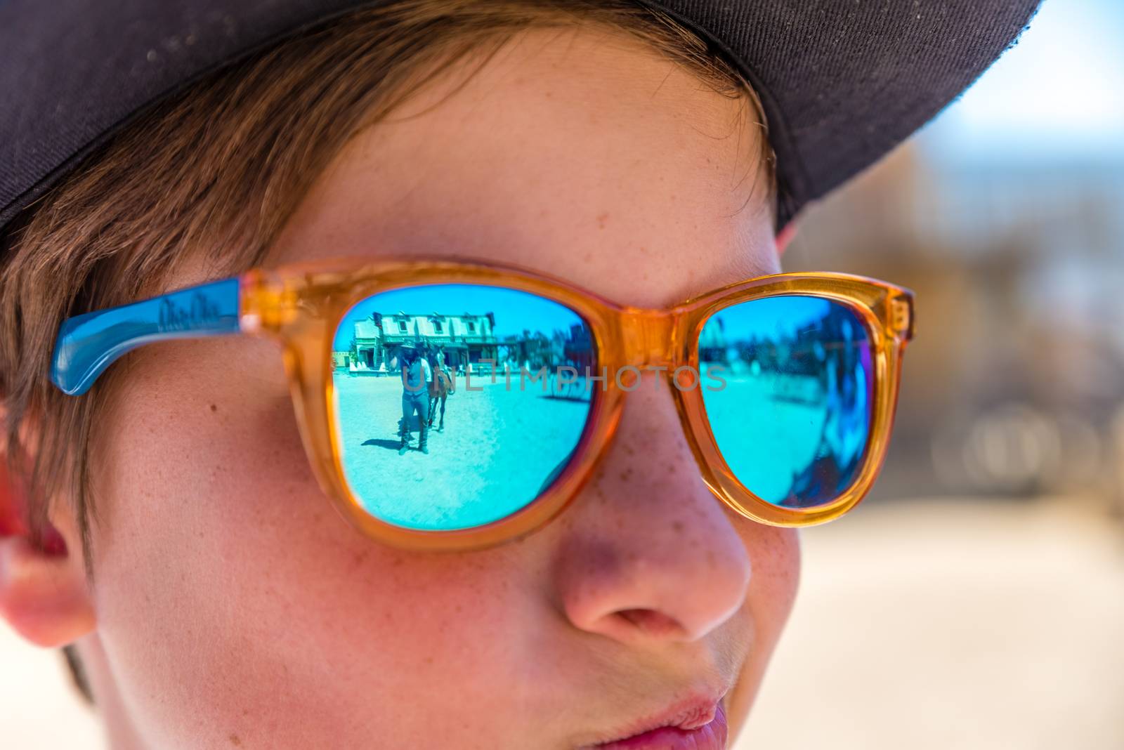 boy with sunglasses watching cowboy show