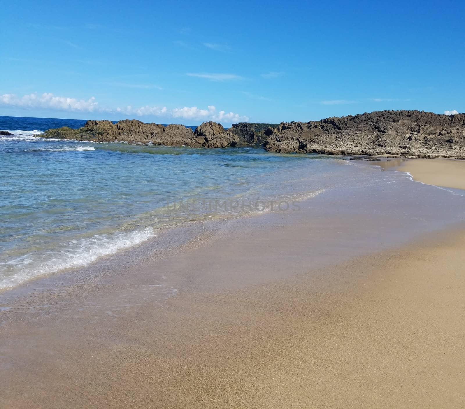 sand and ocean water on beach in Isabela, Puerto Rico by stockphotofan1