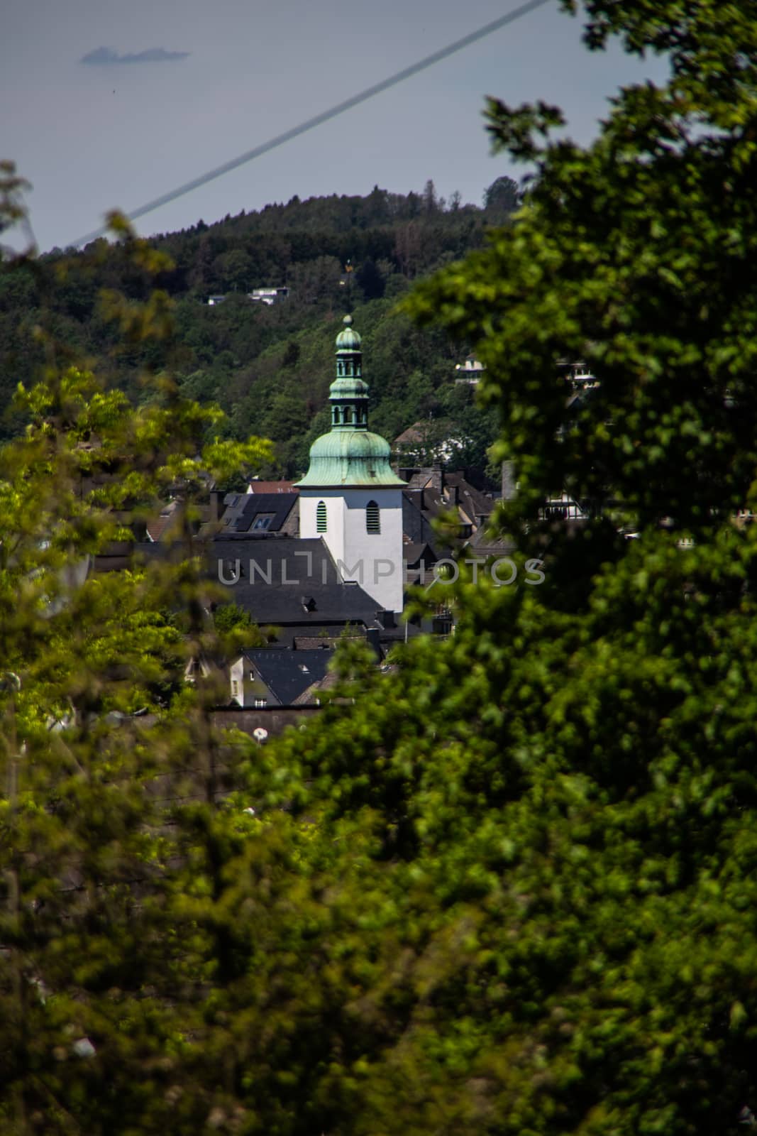 Church tower looks out between the trees