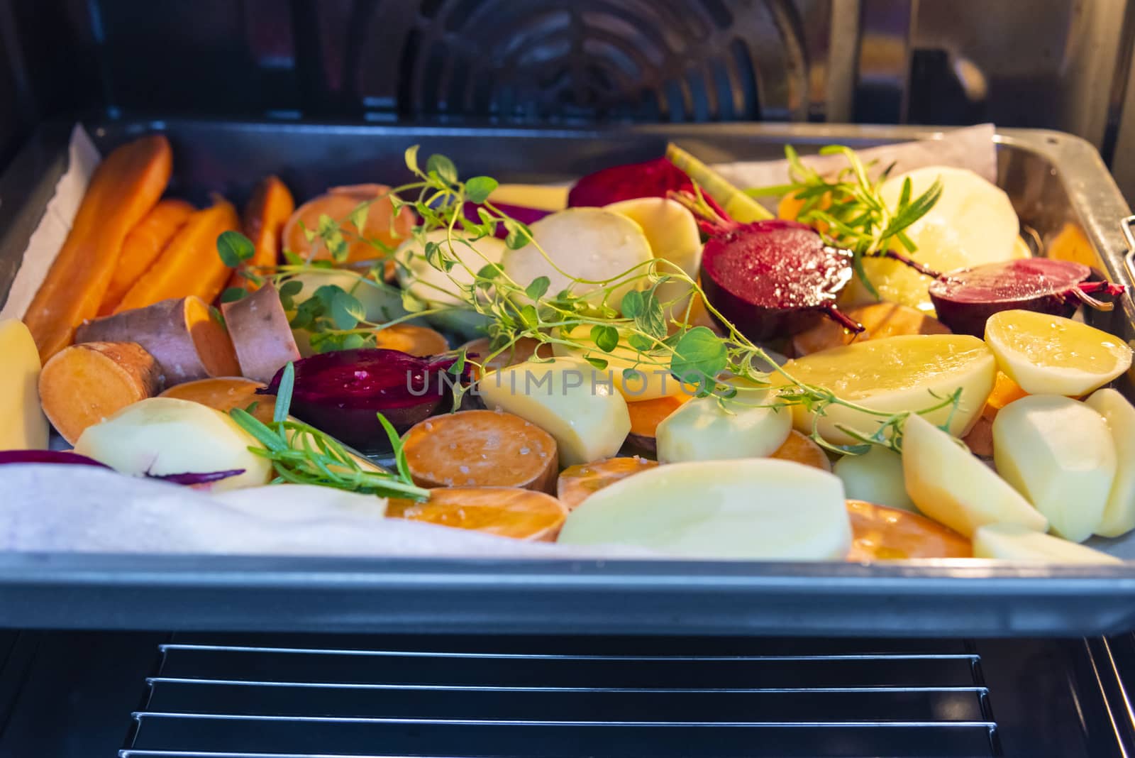 Cut raw vegetables before putting them in the oven. Carrots, potatoes, sweet potatoes, beets, kohlrabi, rosemary, garlic, hyssop