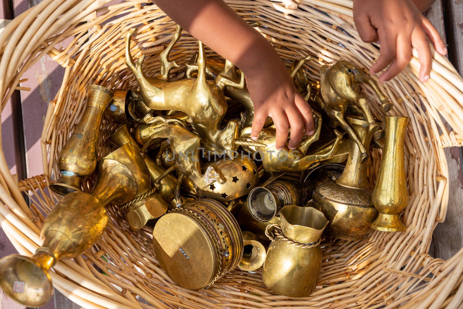 Child hands with a variety of brass collectible objects by magicbones