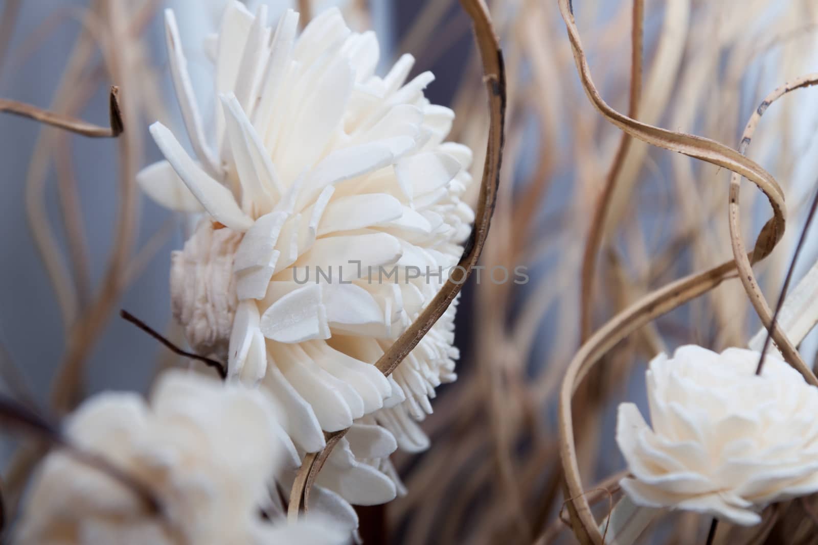 blurred background of dry straw, leaves and artificial flowers by client111