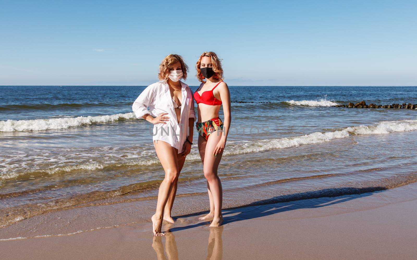 two young blonde girls in a swimsuits and protective masks stand by raddnatt