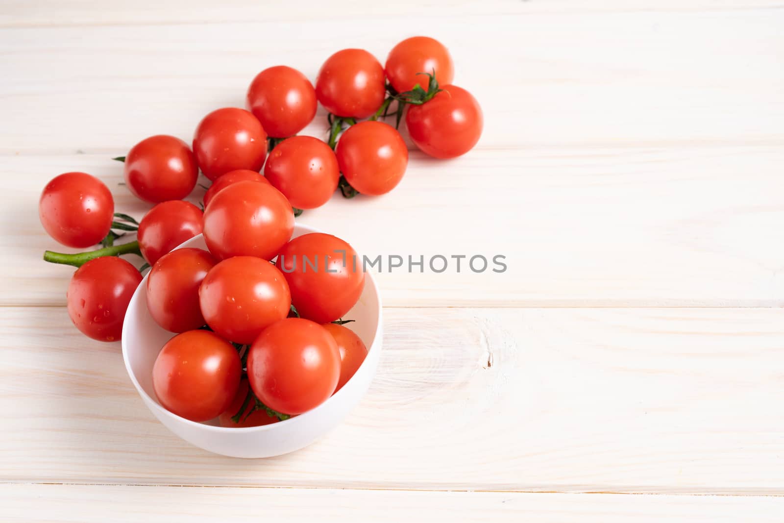 Cherry tomatoes on the white wooden table. Juicy ripe vegetables. Healthy eating. vegetarian food