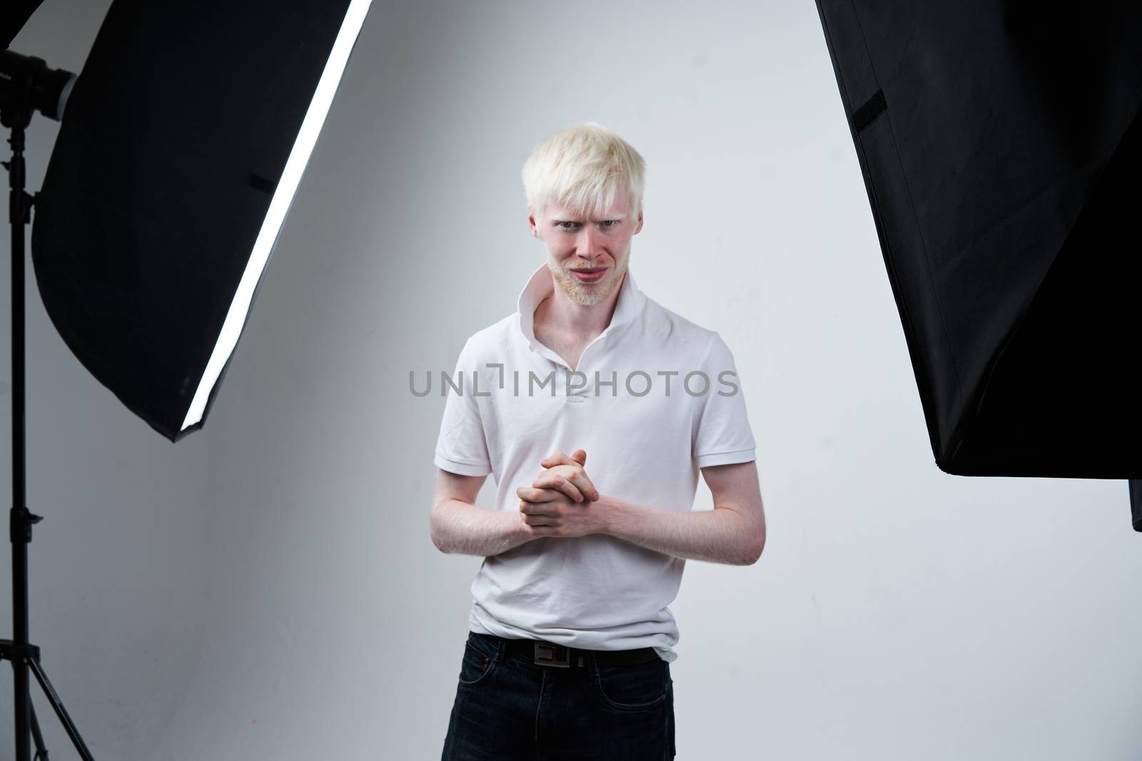 albinism Serious albino man white skin hair studio dressed t-shirt standing flash light. abnormal deviations. unusual appearance. skin abnormality Beautiful people with special appearance.