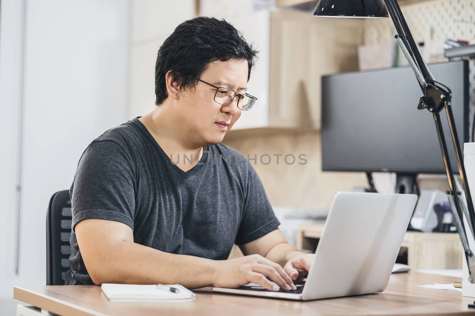 Asian business man using technology laptop for working from home in indoor bedroom of house by video conference call, startups and business owner,lifestyle occupation,social distancing concept