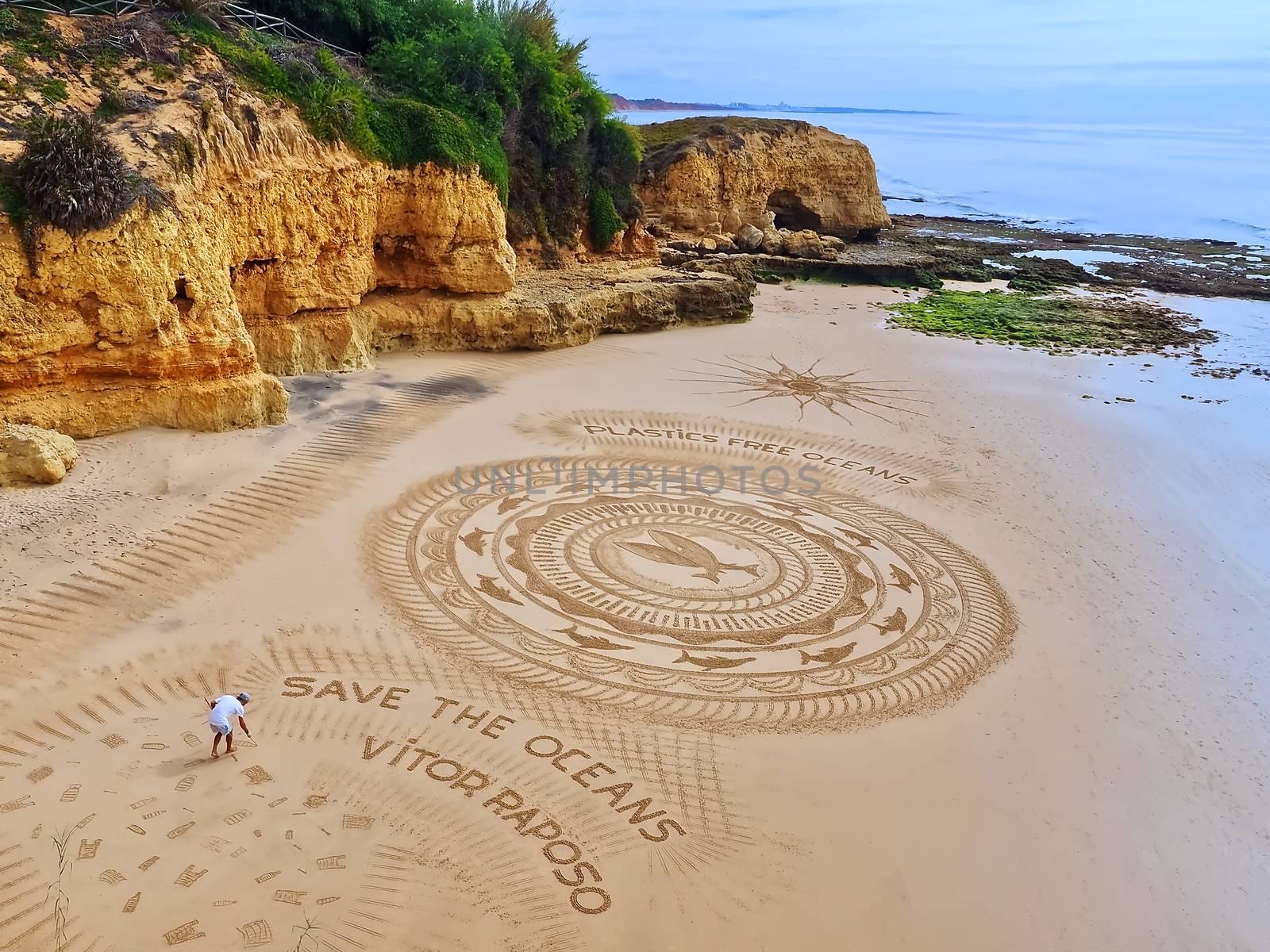 Sand artist Vitor Raposo creates a mandala at a beach in Albufei by Stimmungsbilder