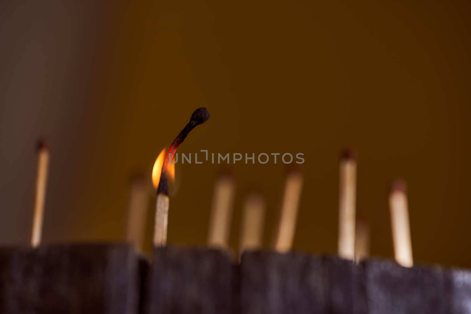 One burning match. wooden matches are on the wooden frame. High quality photo