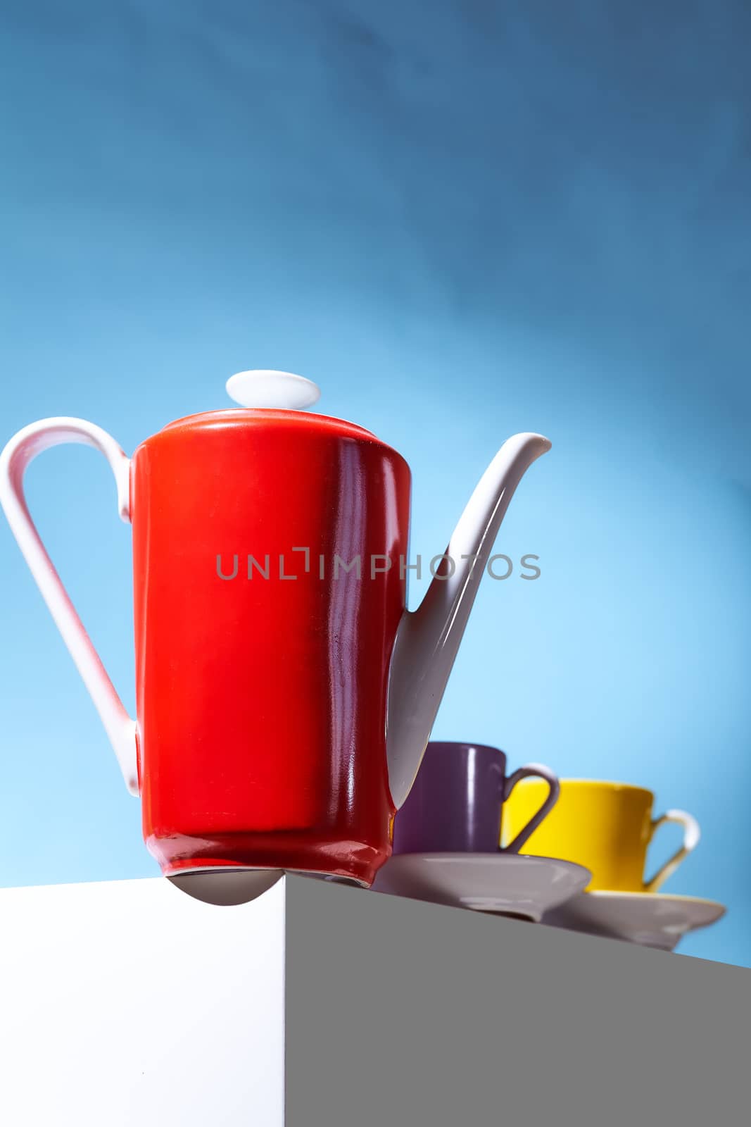 Red coffee teapot and two cup for coffee shop stand on a white cube. High quality photo