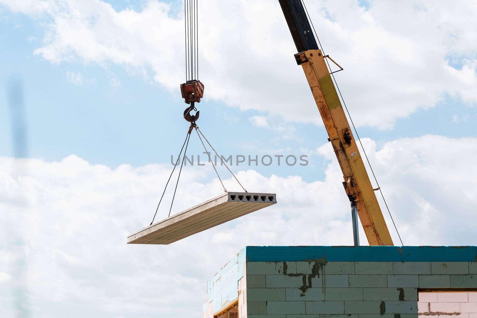 Builder worker installing concrete floor slab panel at building construction site. Second floor house concrete floor slab installation