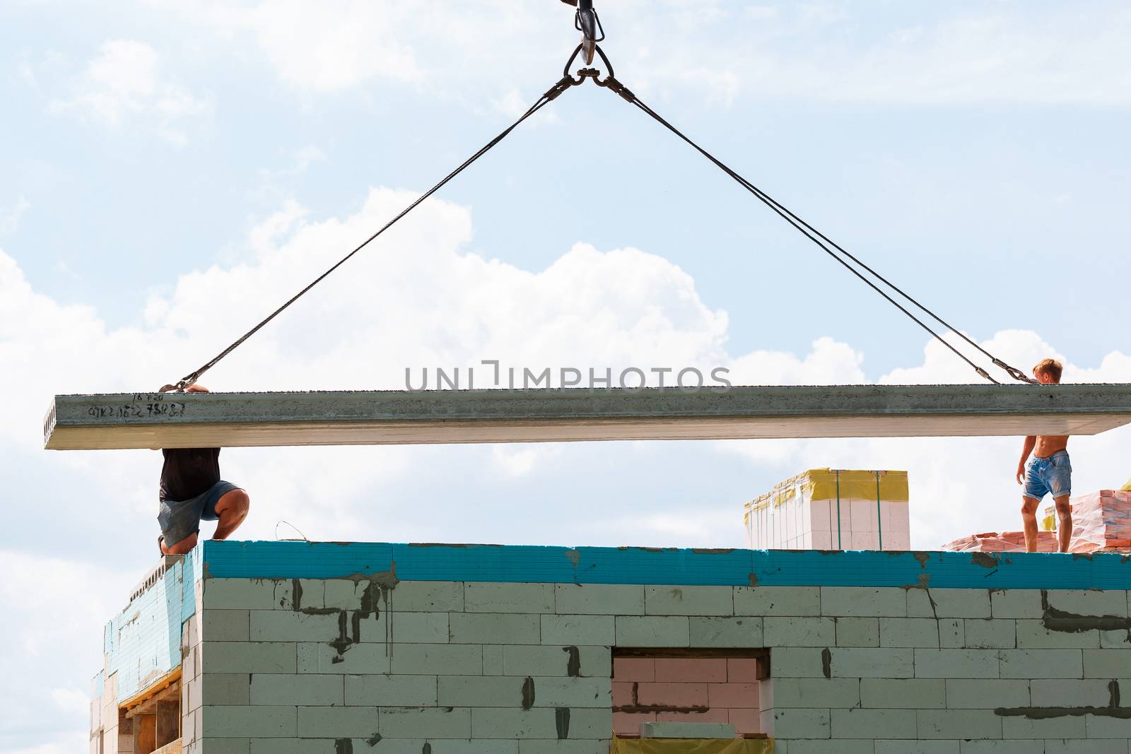 Builder worker installing concrete floor slab panel at building construction site. Second floor house concrete floor slab installation