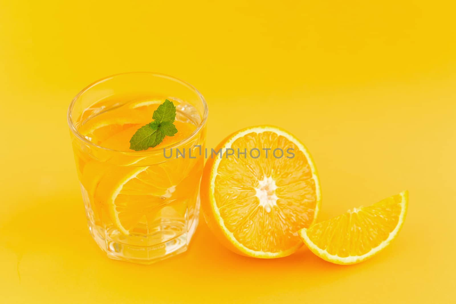 Detox Water with orange in a glass on an orange background by kaiskynet