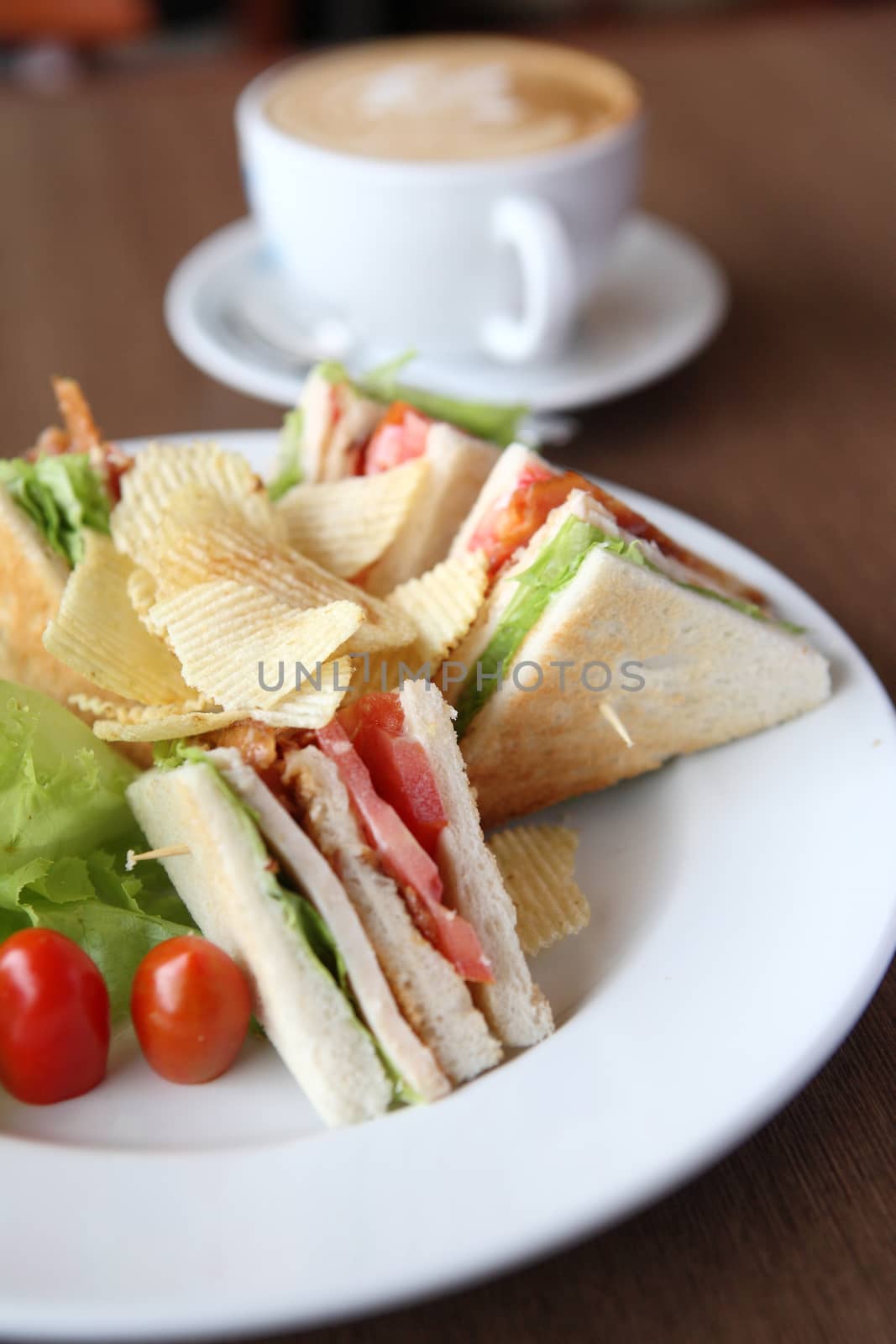 Club sandwich with coffee on wood background